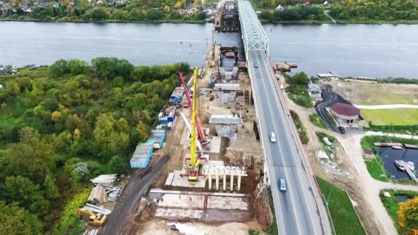 SAN PETERSBURG, RUSIA - 20 DE SEPTIEMBRE DE 2018: Vista aérea de la construcción activa de puentes en la zona cercana a la carretera y al río — Vídeos de Stock