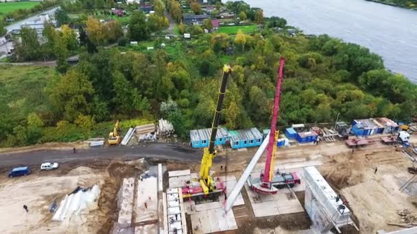 SAINT PETERSBURG, RÚSSIA - SETEMBRO 20, 2018: Vista aérea da construção ativa na área com guindastes grandes vizinhas estrada e rio — Vídeo de Stock