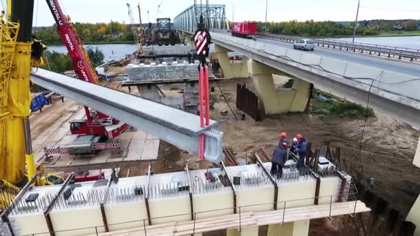 Sankt Petersburg, Rosja-20 września, 2018: dwa żurawie dźwigu betonu Beem AD mostu budowy obszaru w pobliżu drogi i rzeki — Wideo stockowe