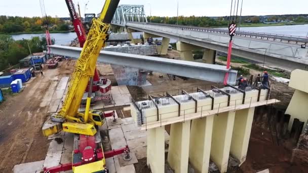 SAINT PETERSBURG, RUSIA - 20 DE SEPTIEMBRE DE 2018: Construcción activa con grúas, con machos al lado del puente sobre el río — Vídeos de Stock