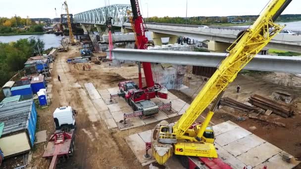 Sankt Petersburg, Rosja-20 września 2018: aktywna budowa mostu na obszarze z dwoma dźwigów w pobliżu drogi i rzeki — Wideo stockowe