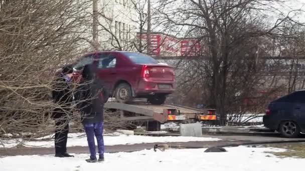 Szentpétervár, Oroszország-június 22, 2019: Maroon autót kapott felrakott az ágyra vontató teherautó a téli utcán. — Stock videók