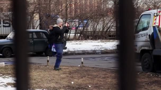 Sint-Petersburg, Rusland-22 juni 2019: Guy in Cap en jas Foto's Maroon auto werd geladen op de trekker vrachtwagen — Stockvideo