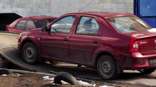 Sankt Petersburg, Ryssland-22 juni 2019: man i mössa och jacka släpper modern rödbrun bil från bogsering lastbil på vintern — Stockvideo