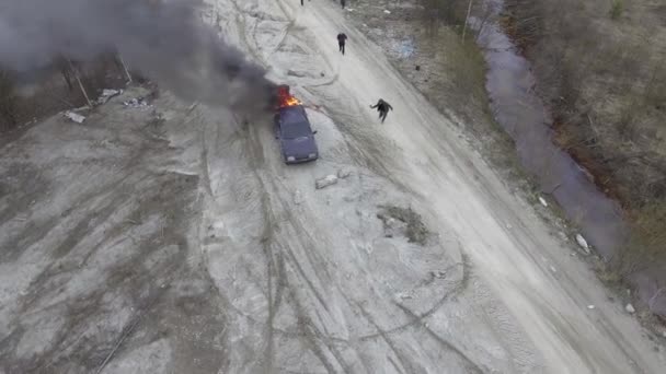 さびれたほこり畑で大きな炎で燃えている車の空中写真. — ストック動画