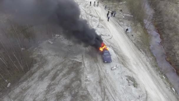 在荒芜的尘土中，用大火焰和浓烟燃烧的汽车的无人机视图. — 图库视频影像