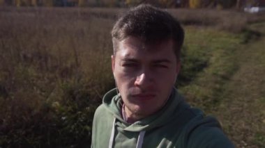 Beyaz tenli yakışıklı genç adam tarlalarda tek başına yürüyor..