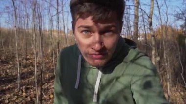 Yeşil kapüşonlu genç adam tarlalarda tek başına yürüyor..