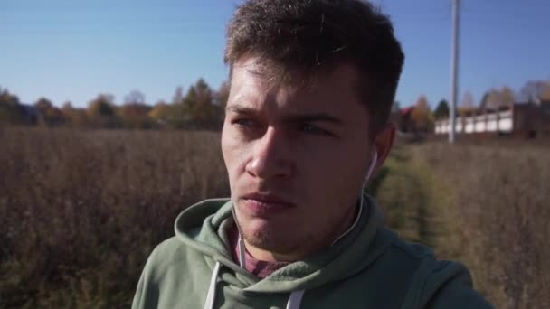 Молодой кавказский квартал гуляет по сельской местности в одиночестве по полям . — стоковое видео
