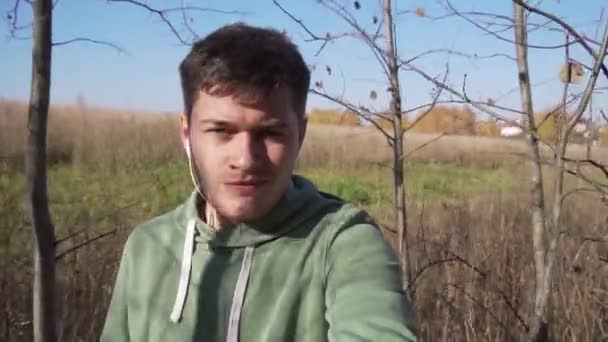 Bello caucasico giovane sta camminando in campagna da solo lungo i campi . — Video Stock