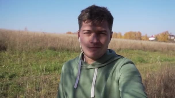 Carino caucasico giovane uomo sta camminando in campagna da solo lungo i campi . — Video Stock