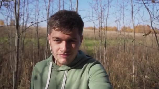 Buen aspecto caucásico joven está caminando en el campo solo a lo largo de los campos . — Vídeo de stock