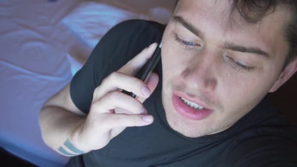 Πρόσωπο χαριτωμένο καυκάσιος άνθρωπος σε σκούρο t-shirt και μπλε μάτια, μιλώντας στο smartphone — Αρχείο Βίντεο