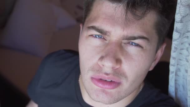 Face of cute caucasian man in dark t-shirt and blue eyes, staring at camera. — Stock Video