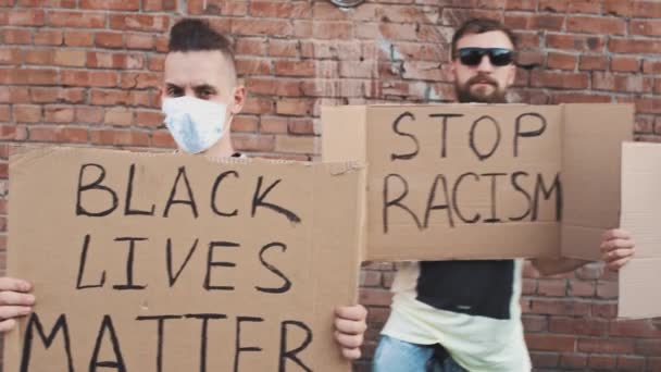4人の白人男性が赤い壁に立ち 手書きの段ボールポスターで碑文を付けている ブラックライフ問題 人種差別を止める すべての人生問題 ホワイトライフ問題 ストック動画 C Bazava