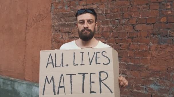 Homem Caucasiano Barbudo Máscara Está Contra Parede Vermelha Com Cartaz — Vídeo de Stock