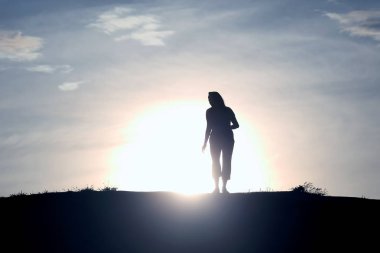 Batan güneşin bir kadın silüeti