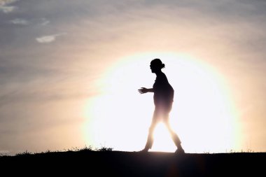 Batan güneşin bir kadın silüeti