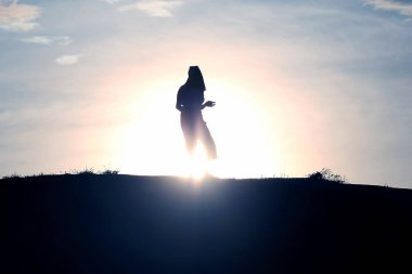 Batan güneşin bir kadın silüeti