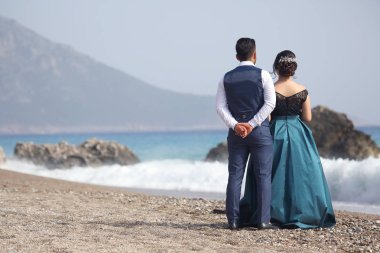 zarif giyimli adam ve kadın sahilde