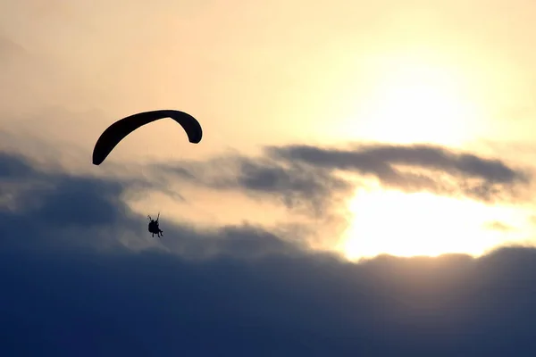 Bir Kanat Karşı Batan Güneşin Gökyüzünde Uçan Yamaçparaşütü — Stok fotoğraf