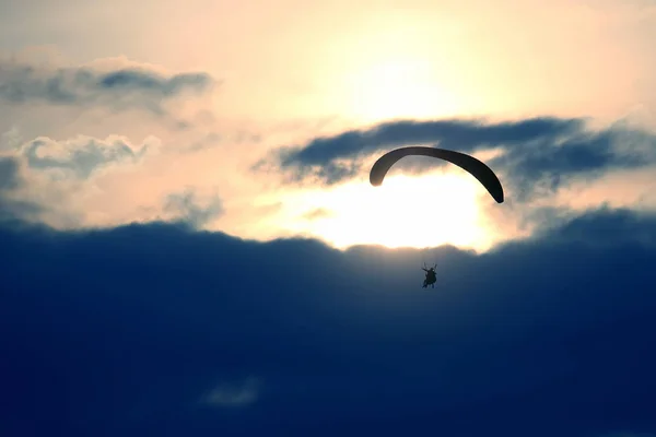 Bir Kanat Karşı Batan Güneşin Gökyüzünde Uçan Yamaçparaşütü — Stok fotoğraf