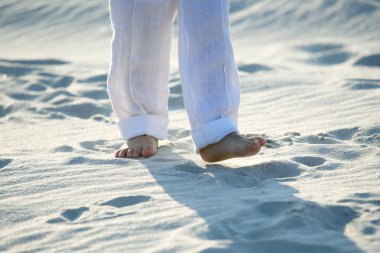 bir çocuğun Beyaz pantolonlu san üzerinde çıplak ayak