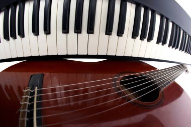 Beyaz arka plan üzerinde klasik gitar ve piyano tuşları kapat