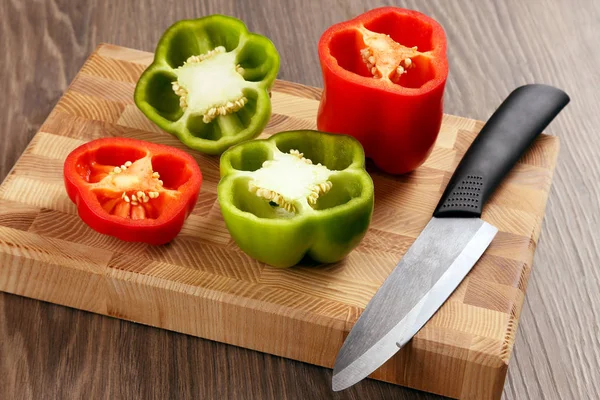 sliced sweet peppers with a ceramic knife on a wooden board
