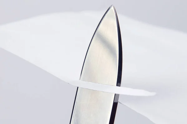 ホワイト ペーパーを横切る鋭いナイフの刃 — ストック写真