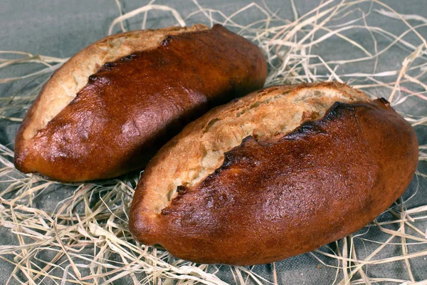 Δύο Λευκό Ψωμί Που Βρίσκεται Άχυρα Στην Γκρίζα Τραπεζομάντιλο Λινού — Φωτογραφία Αρχείου