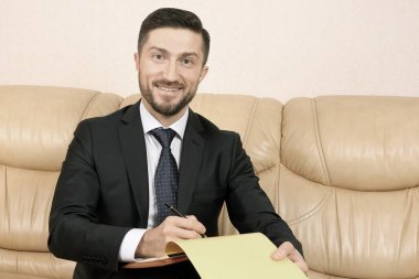 başarılı iş adamı bir deri üzerinde oturan iş belgelerle sof
