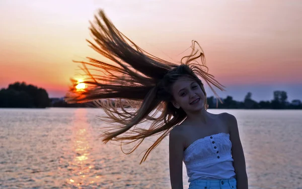 Gün Batımında Uzun Saçlı Başını Sallayarak Genç Kız — Stok fotoğraf