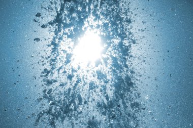 Batan güneşin altındaki çeşmenin damlaları.