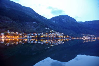 Gece şehir Odda su yansıması. Norveç