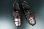 Klasické pánské hnědé Oxford boty na tmavém pozadí
