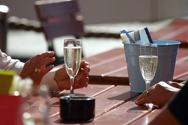 people communicate on the street with glasses of champagne