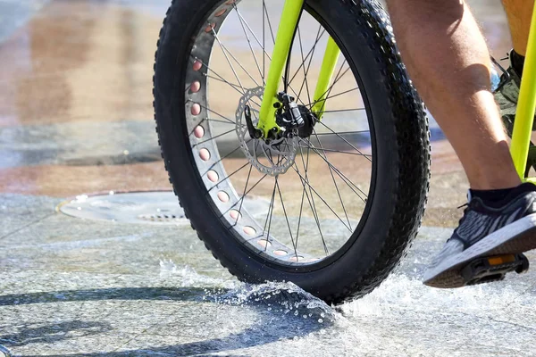 骑车的自行车上有厚轮子骑在潮湿的人行道上 — 图库照片