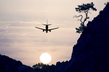 gün batımında akşam gökyüzünde uçan jet yolcu uçağı