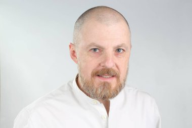 Hafif arka planda sakallı bir adamın portresi.