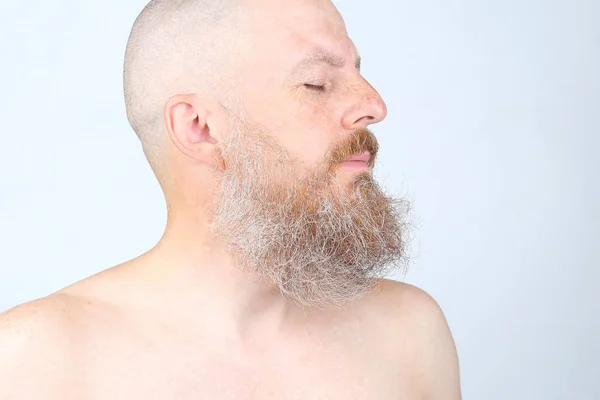 光の背景に髭を生やした男の肖像画 — ストック写真