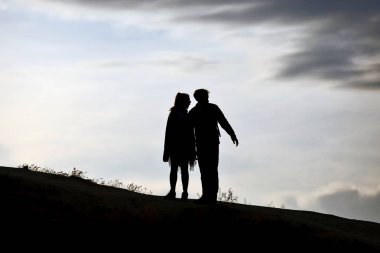 Fotoğraf batan güneşin karşı alan insanlar silüeti