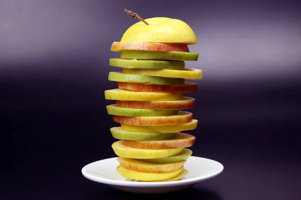 Sliced Apple on white plate on dark backgroun