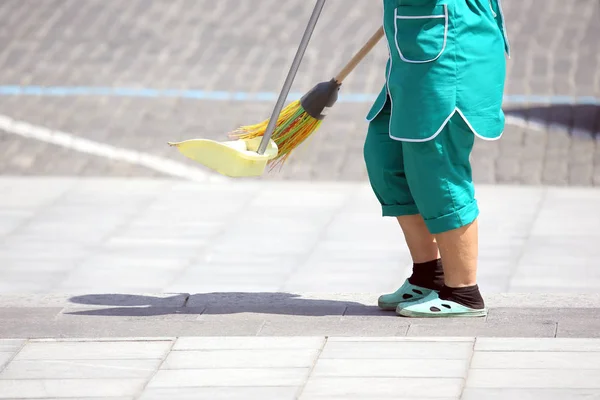 janitor cleans the sidewalk of the city