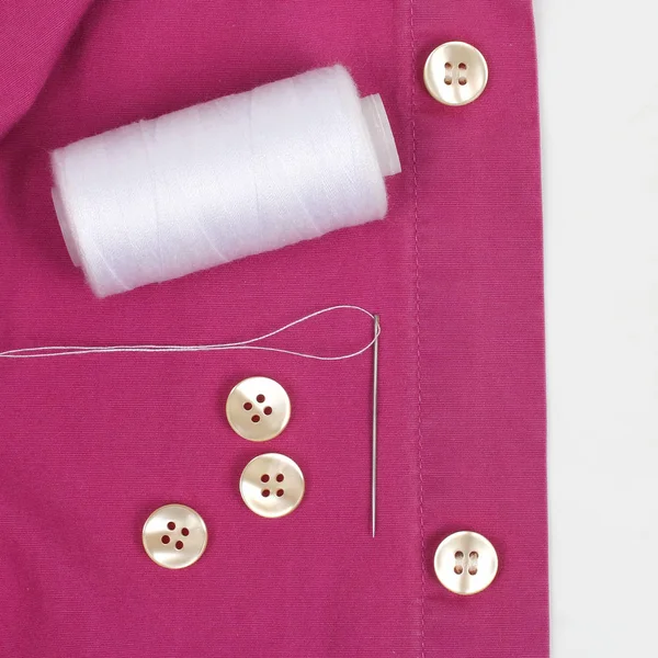 Bobina con fili bianchi e un ago e bottoni di perle cuciti su t — Foto Stock