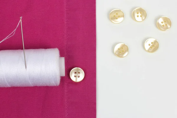 Aguja con hilos blancos y botones de perlas cosidas en la camisa — Foto de Stock