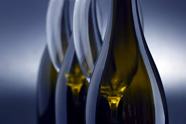 Tři vína lahví a dvě prázdné víno, které brýle zblízka — Stock fotografie