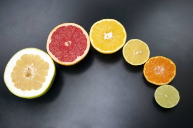 Koyu arkaplanda farklı turunçgil meyveleri kes