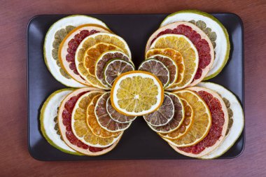 Narenciye meyve dilimleri karanlık bir plaka üzerinde kurutulmuş