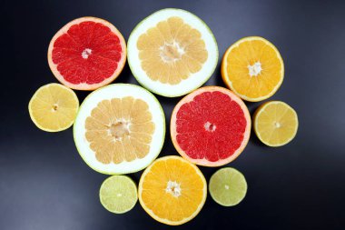 Koyu arkaplanda farklı turunçgil meyveleri kes